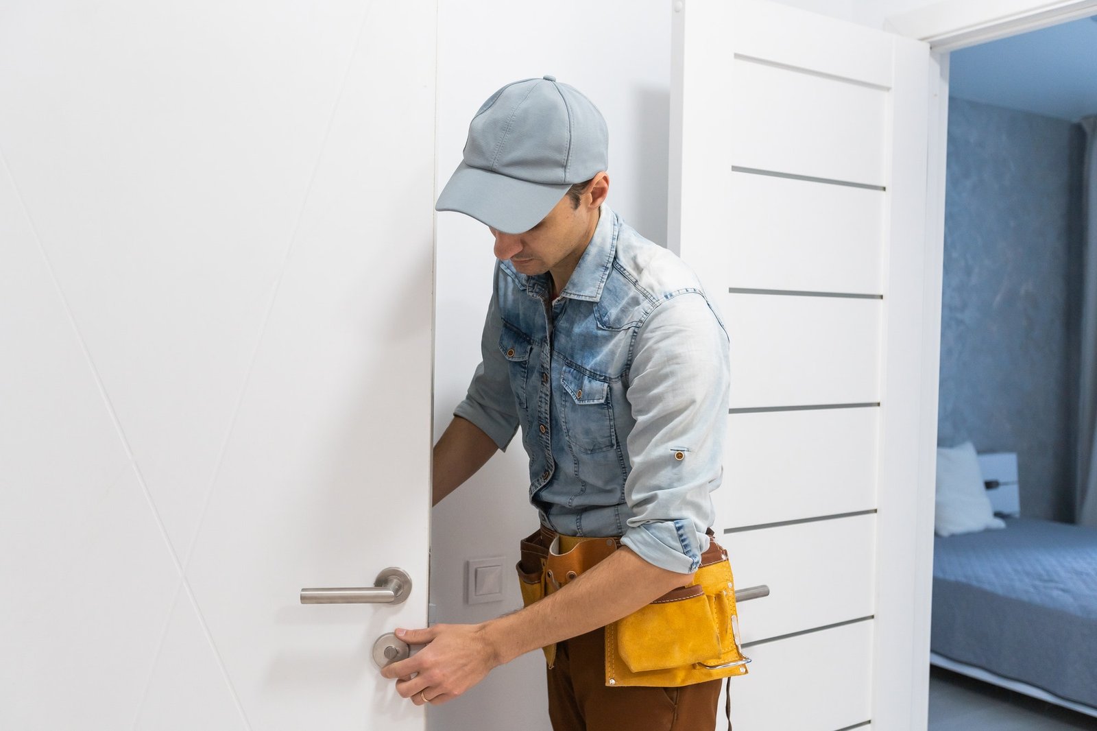 installation of a lock on the front wooden entrance door portrait of young locksmith workman